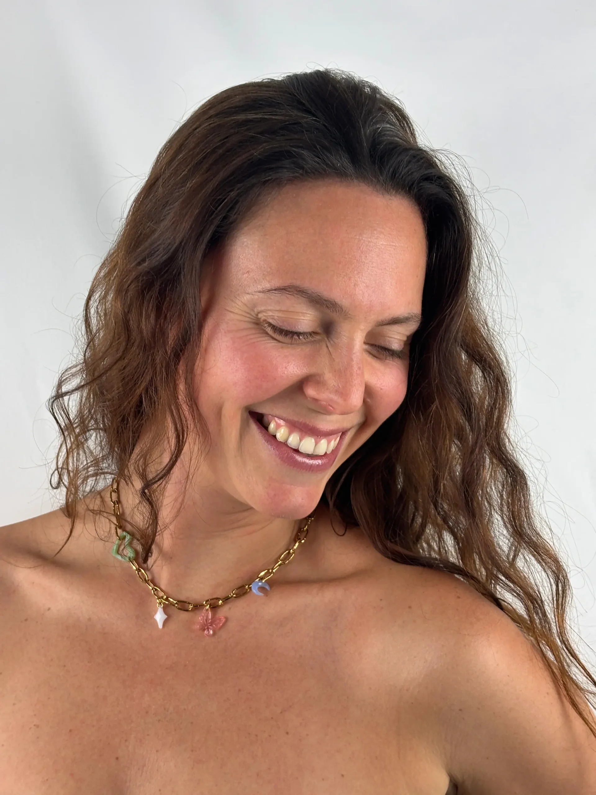 Collier "Pauline", cinq charms porté sur une fille souriante