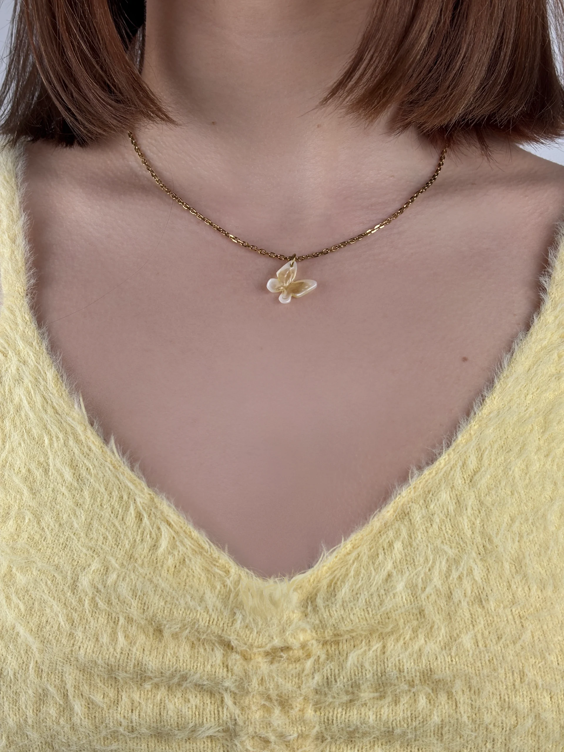 Collier fin avec pendentif papillon jaune et blanc accordé un haut jaune poussin.