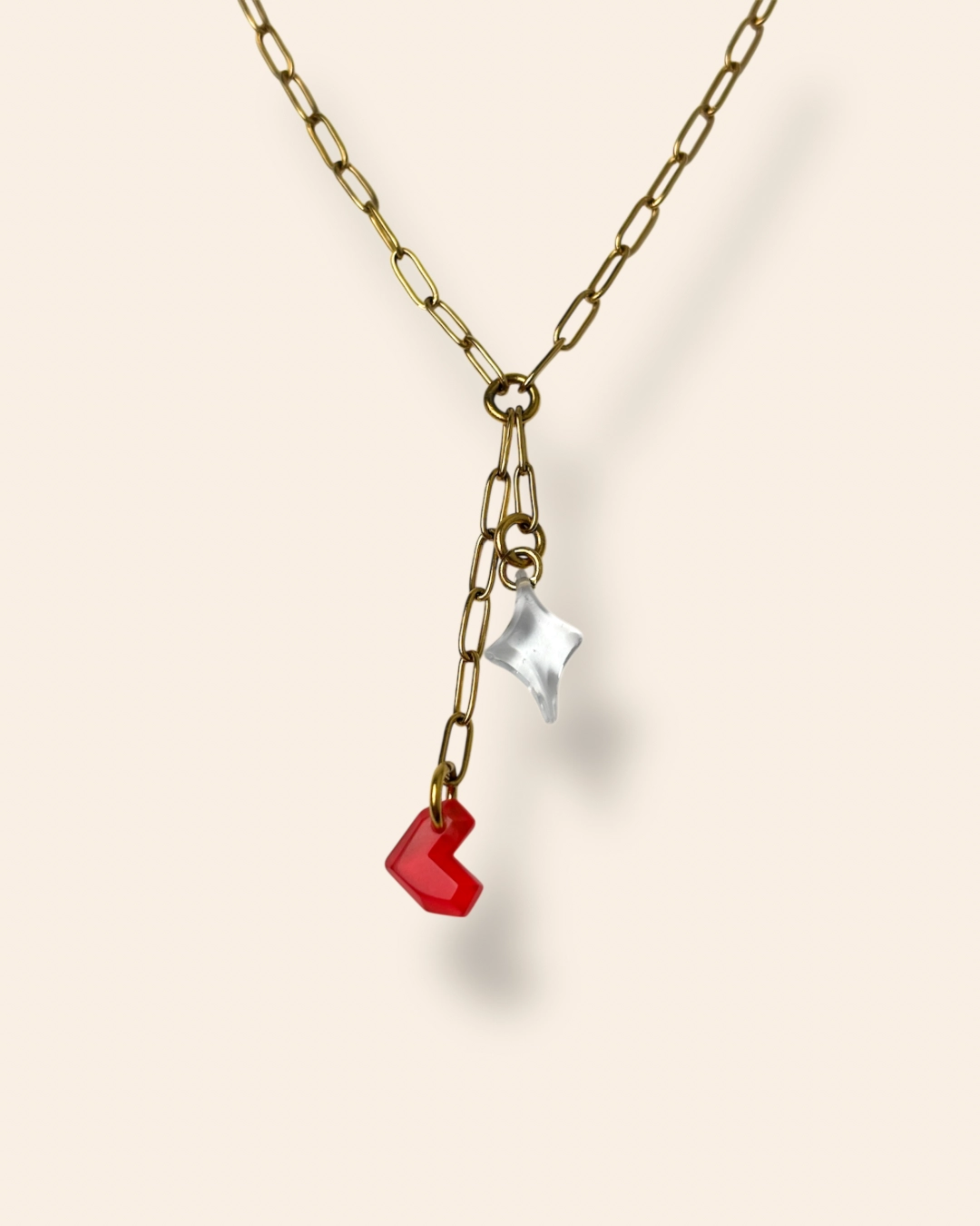 Collier en cascade cœur rouge et étoile transparent fond beige