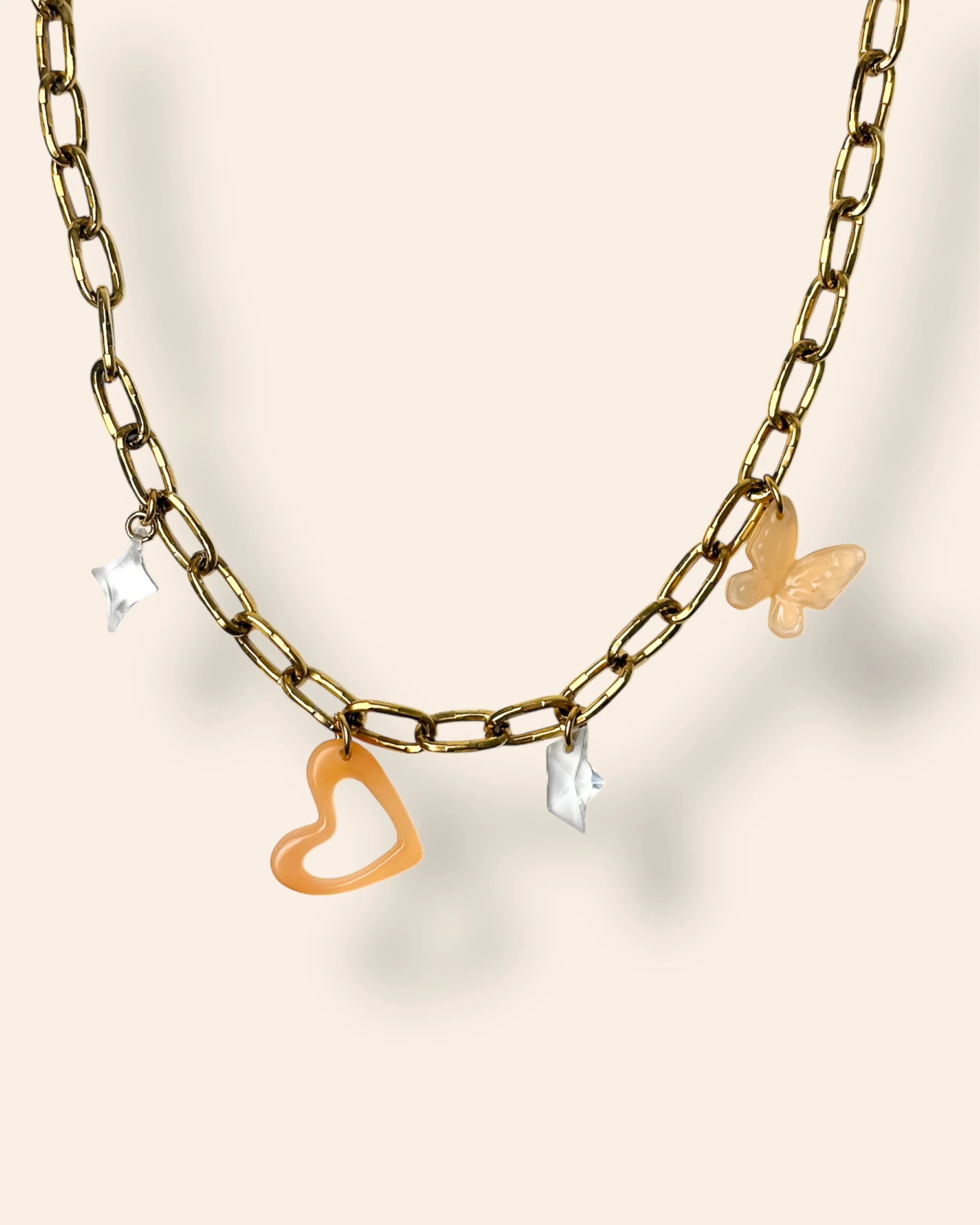 Collier quatre Charms, une étoile transparente, un cœur ajouré et organique orange, un bateau transparent, un papillon orange