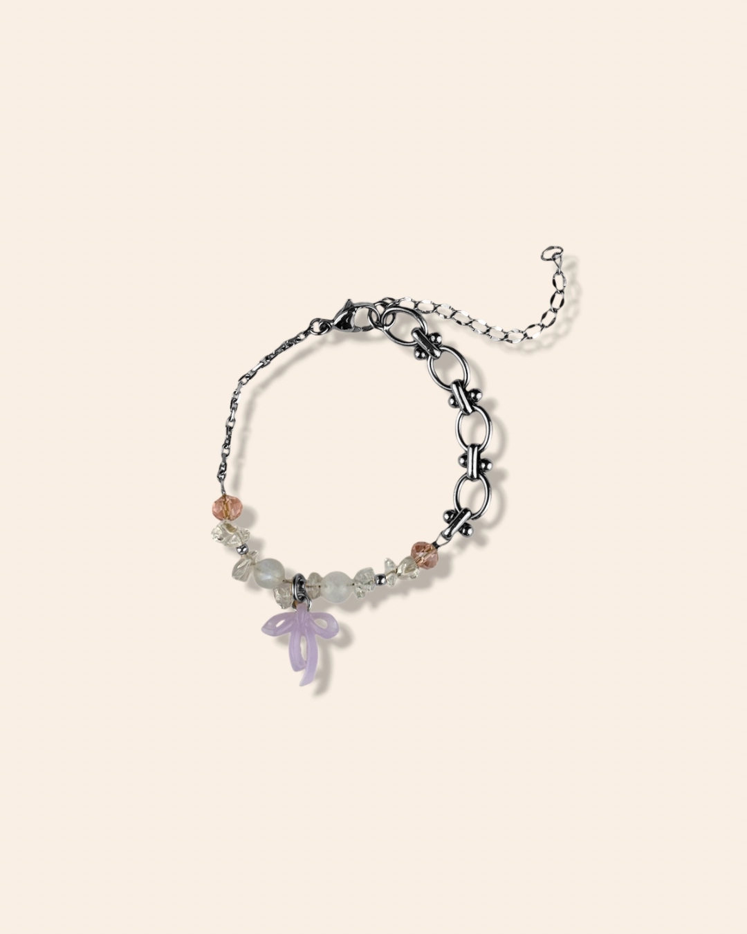 Bracelet asymétrique, tendance et girly aux couleurs pastels. Mélange de perles, pierres naturelles et chaine en acier inoxydable. Orné de trois noeuds faits main.