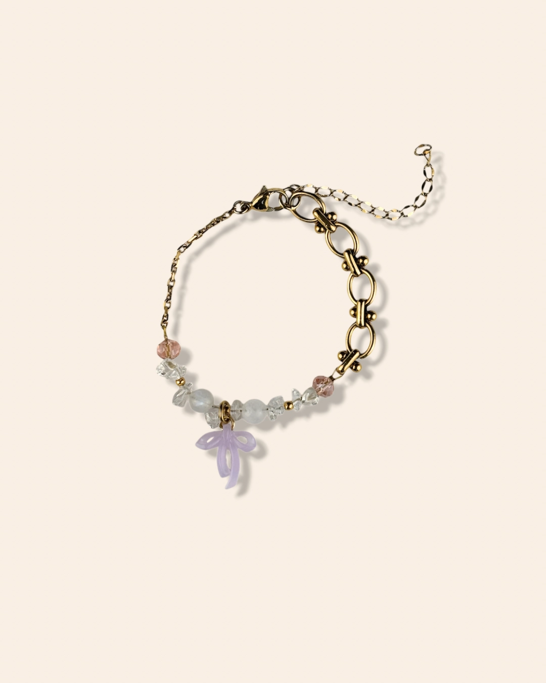 Bracelet asymétrique, tendance et girly aux couleurs pastels. Mélange de perles, pierres naturelles et chaine en acier inoxydable. Orné de trois noeuds faits main.