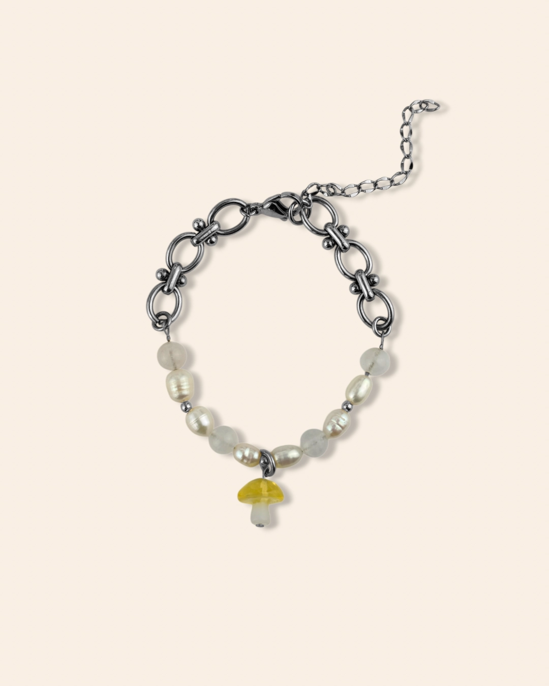 Bracelet tendance argenté associant perles d'eau douces, pierres de lune et acier inoxydable. Bracelet orné d'un pendentif champignon jaune.