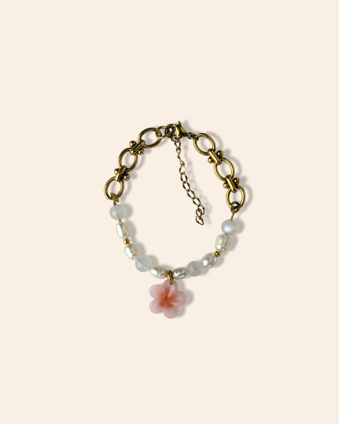 Bracelet printemps associant perles d'eau douces, pierres de lune et acier inoxydable. Bracelet orné d'un pendentif fleur de cerisier.