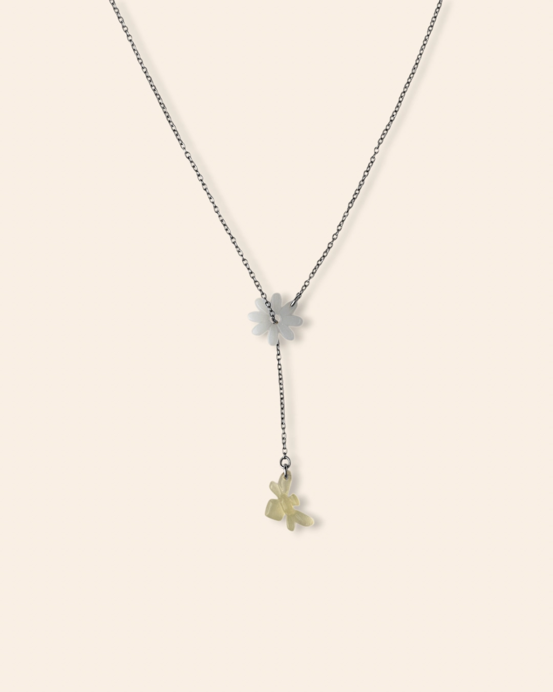 Collier en cascade coulissant fin et raffiné orné d'un pendentif marguerite et d'une abeille.