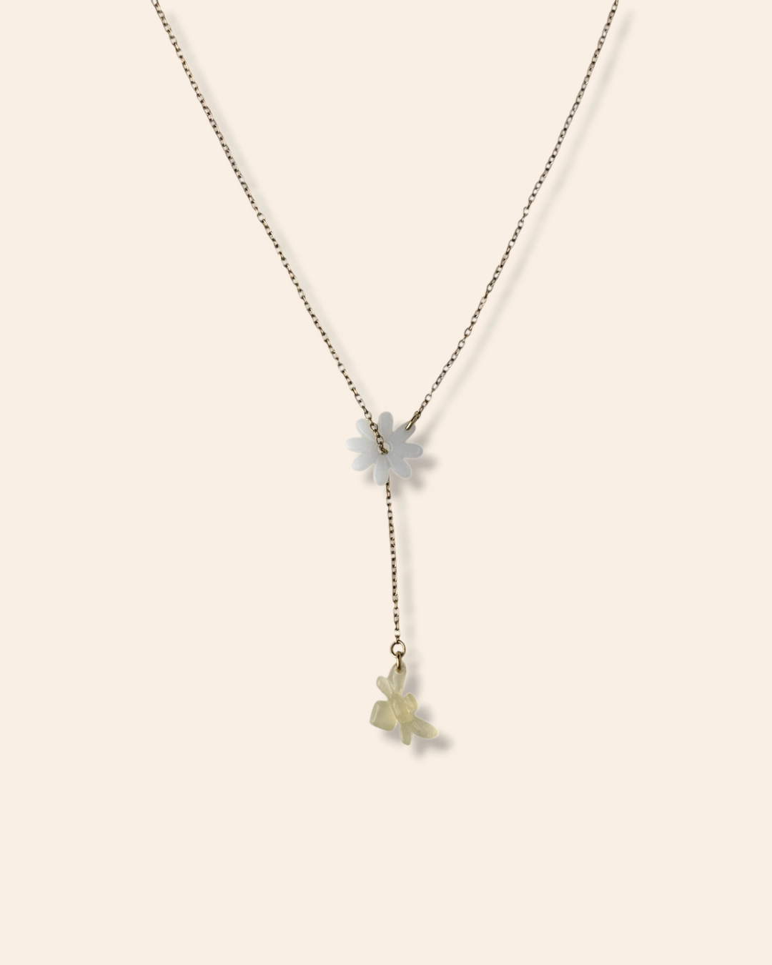 Collier en cascade coulissant fin et raffiné orné d'un pendentif marguerite et d'une abeille.