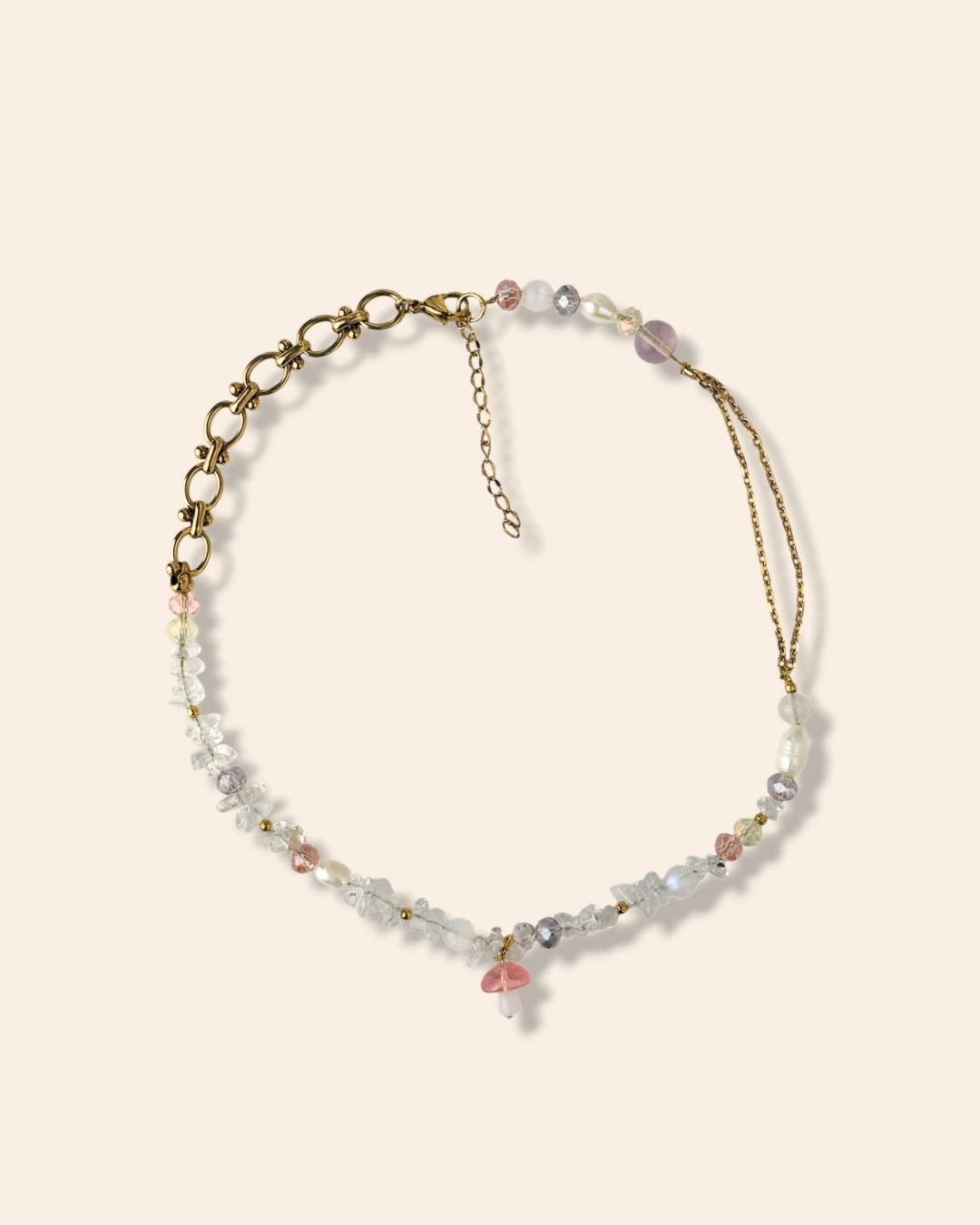 Collier tendance et asymétrique en perle de verre orné d'un charm champignon rose.