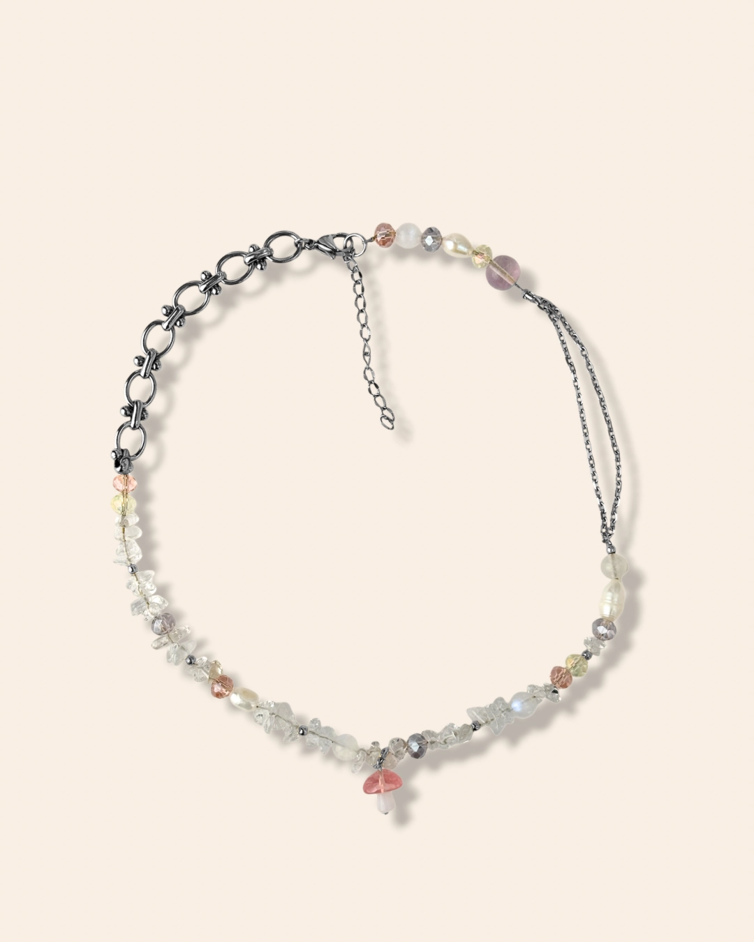 Collier tendance et asymétrique en perle de verre orné d'un charm champignon rose.
