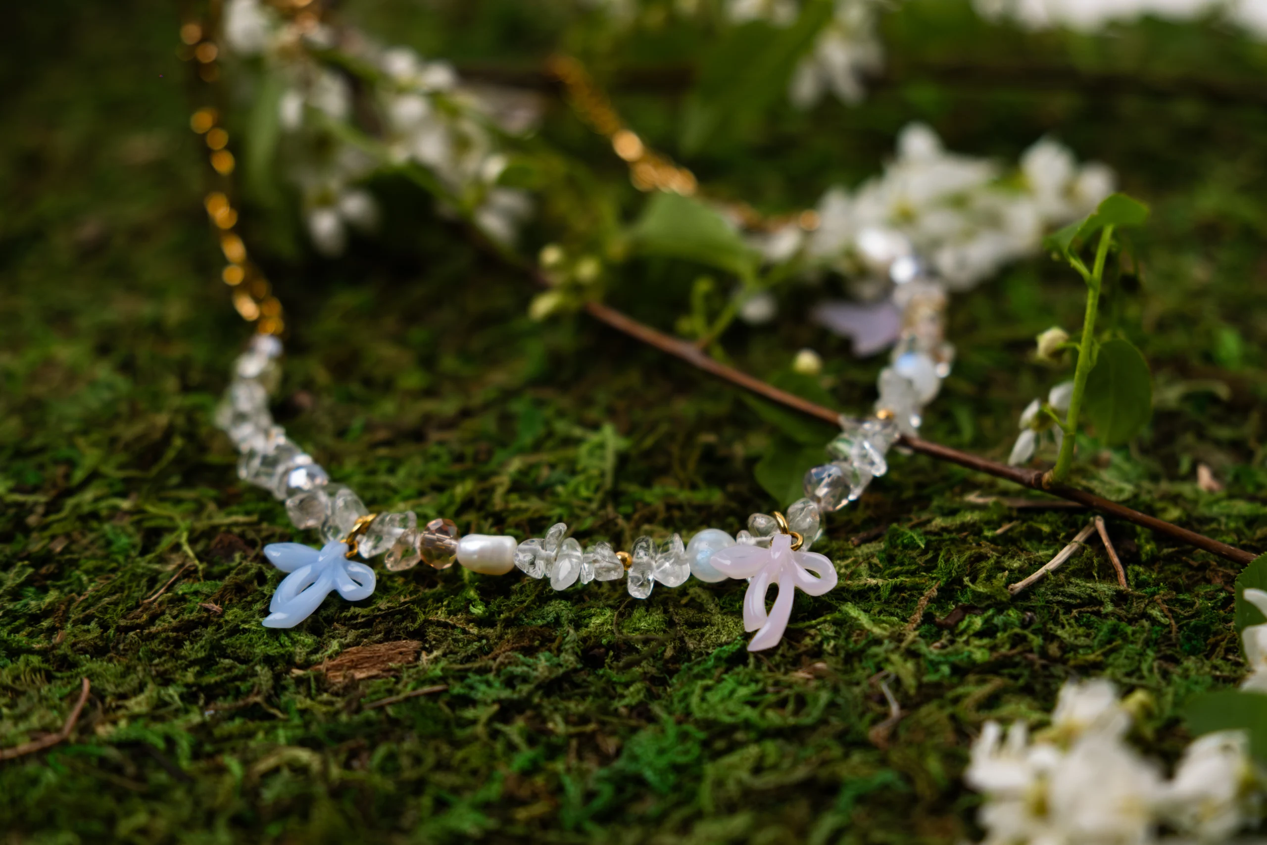 Collier asymétrique, tendance et girly aux couleurs pastels. Mélange de perles, pierres naturelles et chaine en acier inoxydable. Orné de trois noeuds faits main.