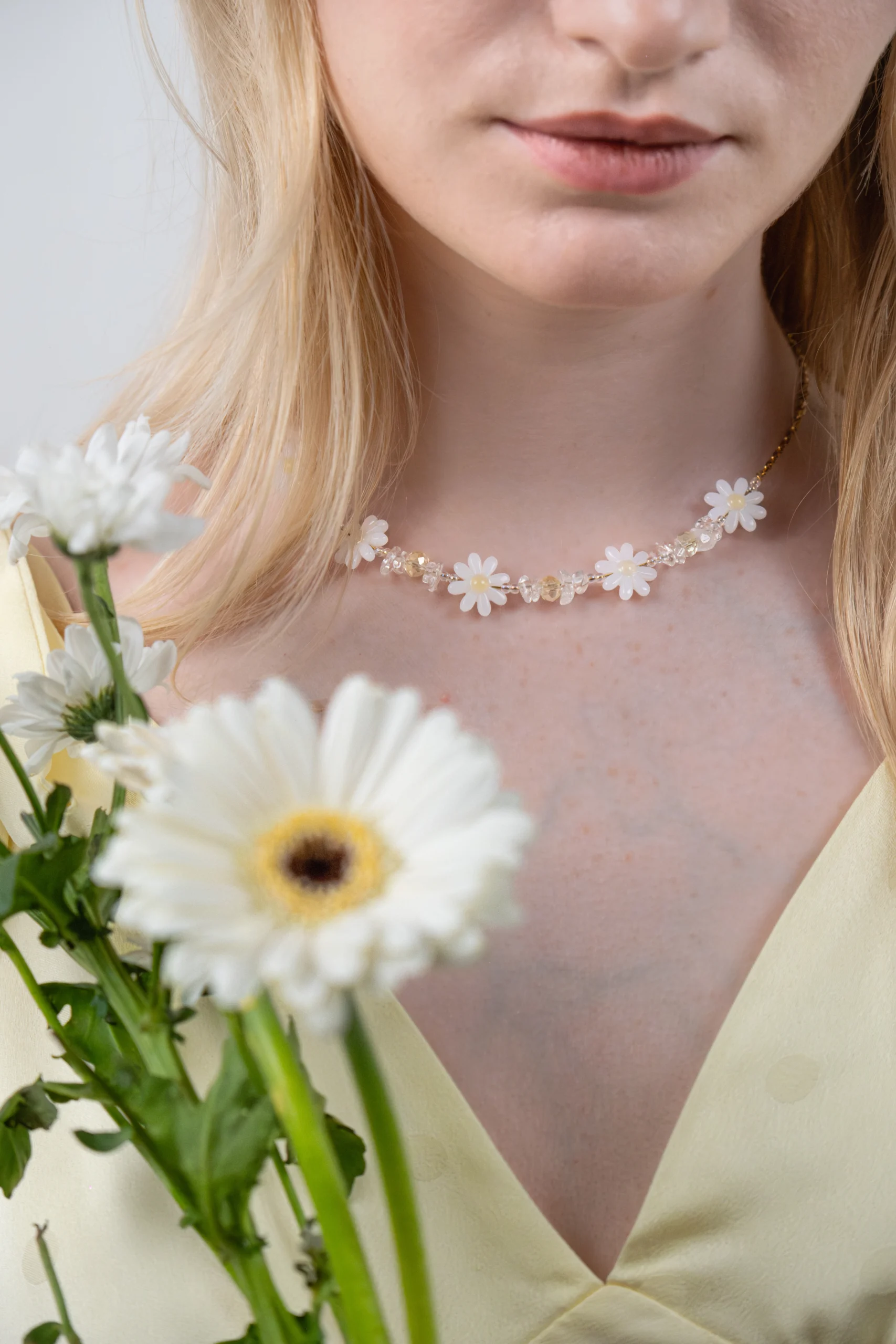 Collier Marguerite et perle tendance dans les tons jaune, transparent et blanc.