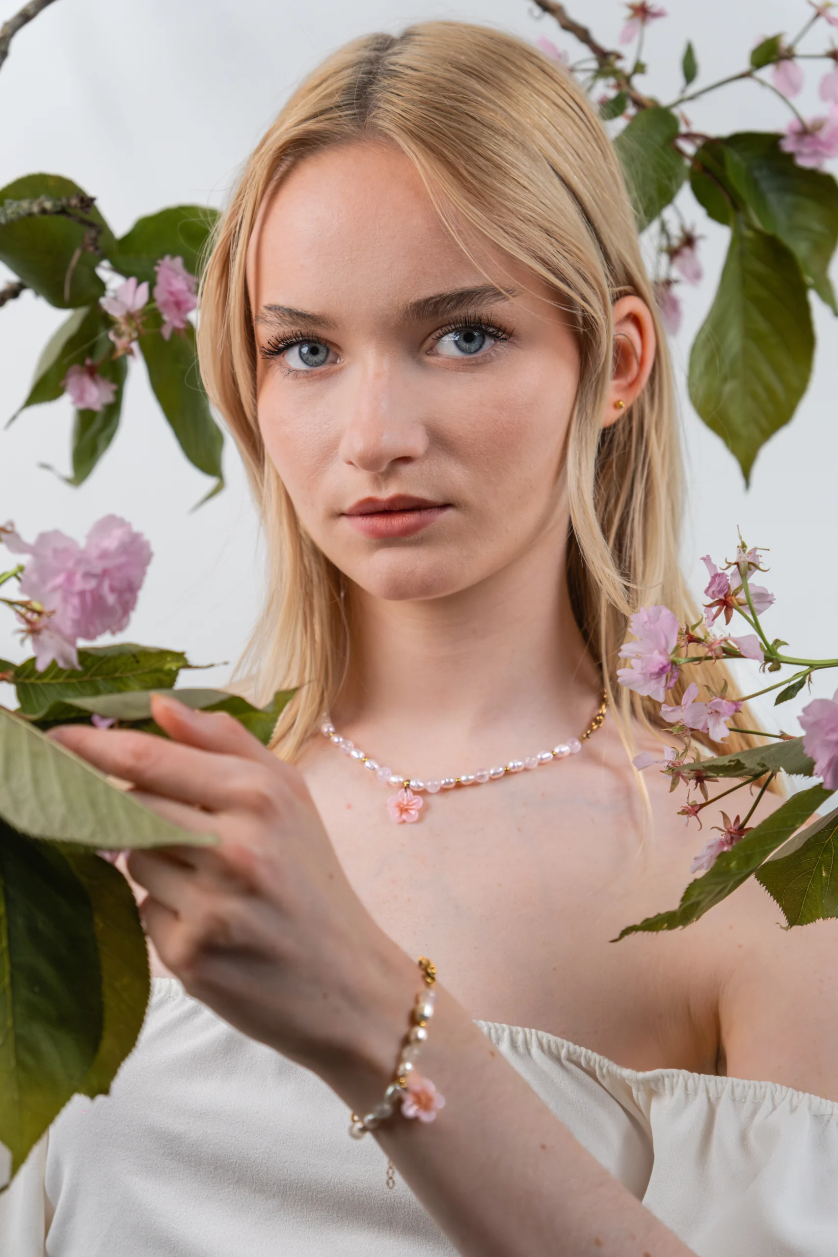 Collier printemps associant perles d'eau douces, pierres de lune et acier inoxydable. Collier orné d'un pendentif fleur de cerisier.