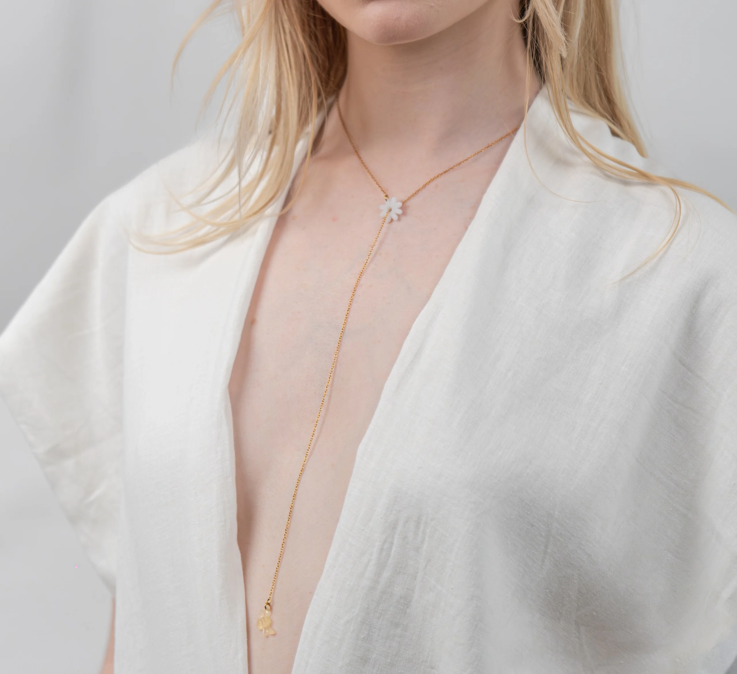 Collier en cascade coulissant fin et raffiné orné d'un pendentif marguerite et d'une abeille.