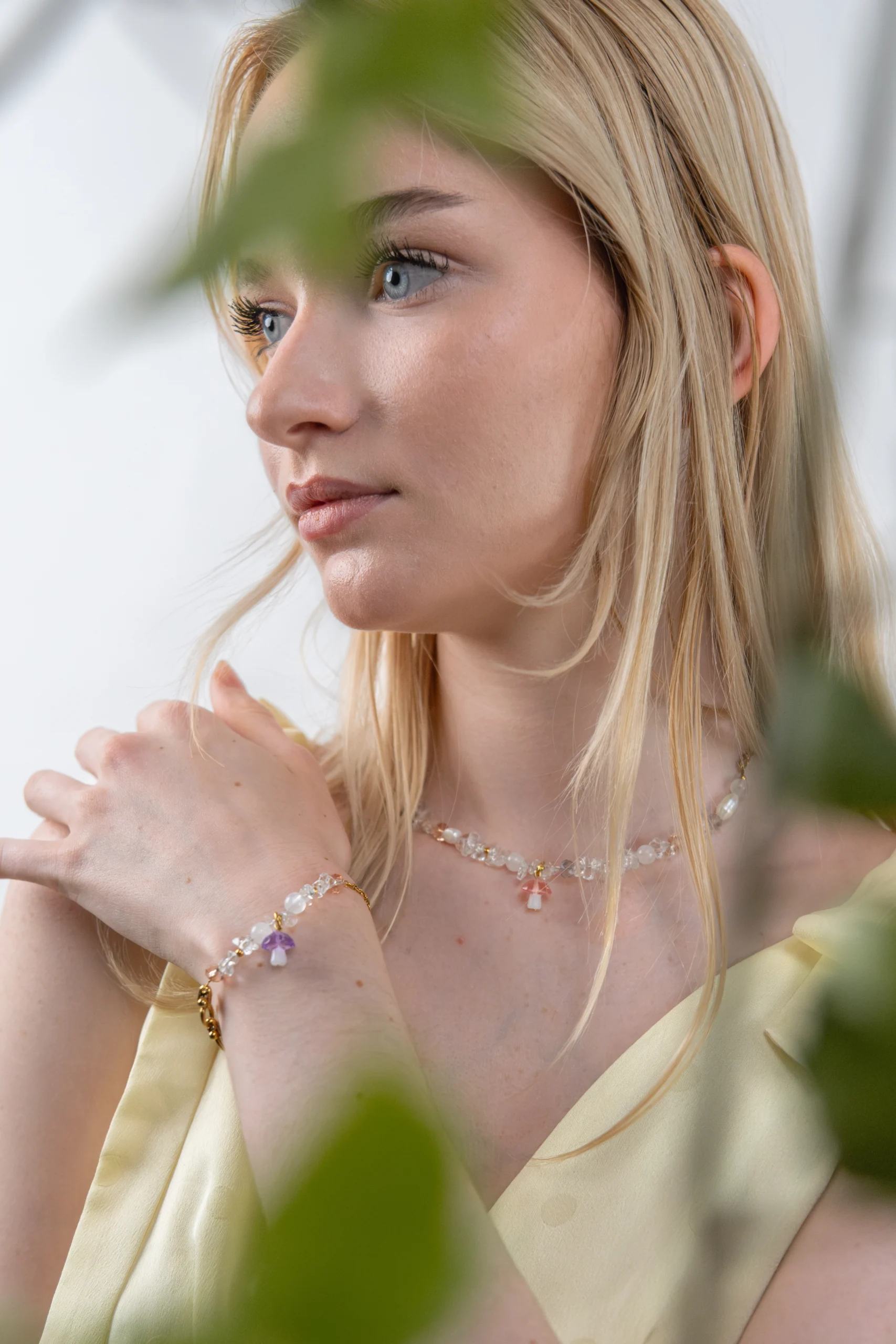 Collier tendance et asymétrique en perle de verre orné d'un charm champignon rose.