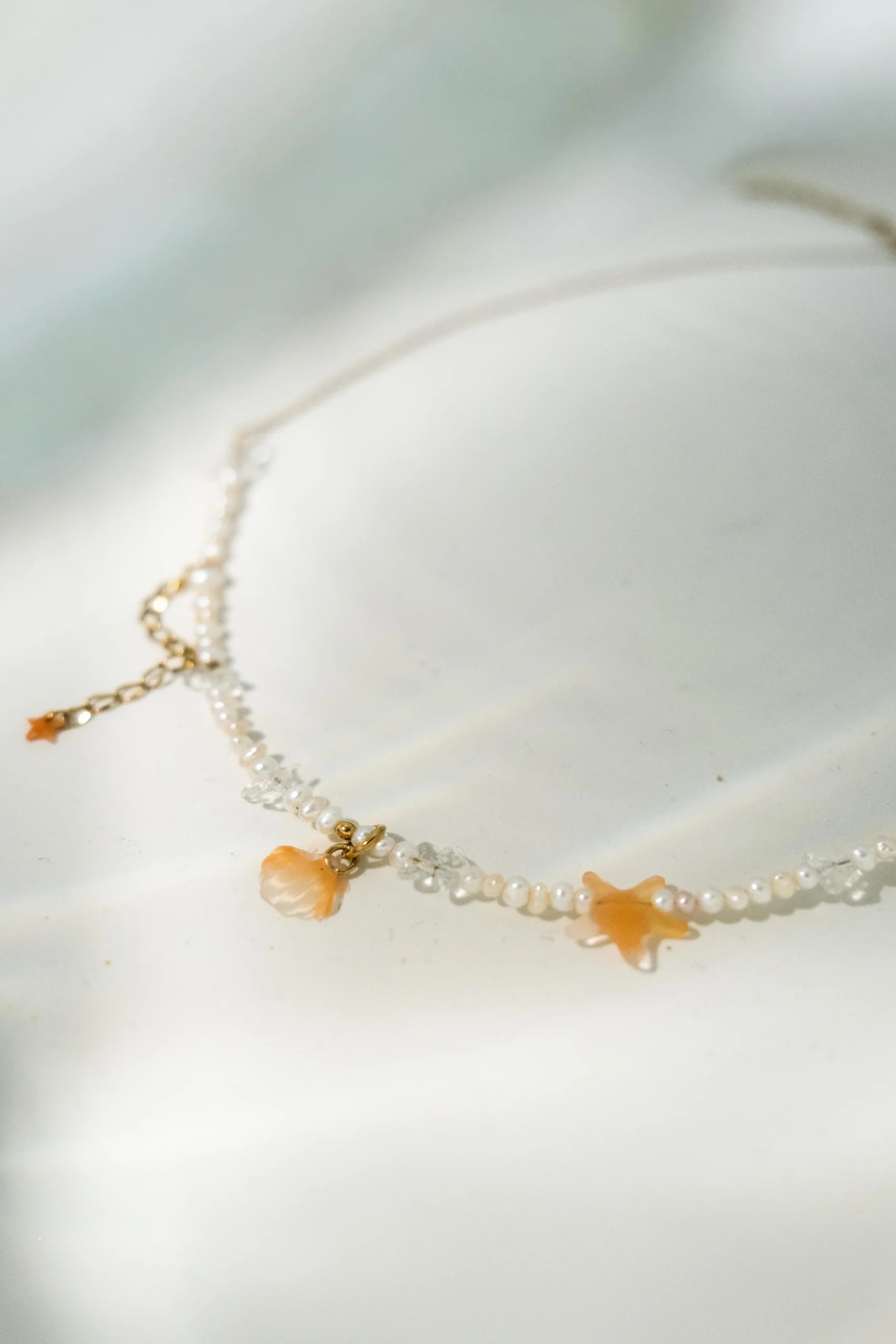 Collier Sand Tide en chaîne dorée avec perles d'eau douce, pierres naturelles et charms coquillage et étoile de mer abricot, collection Mermaid Odyssée Bijoux