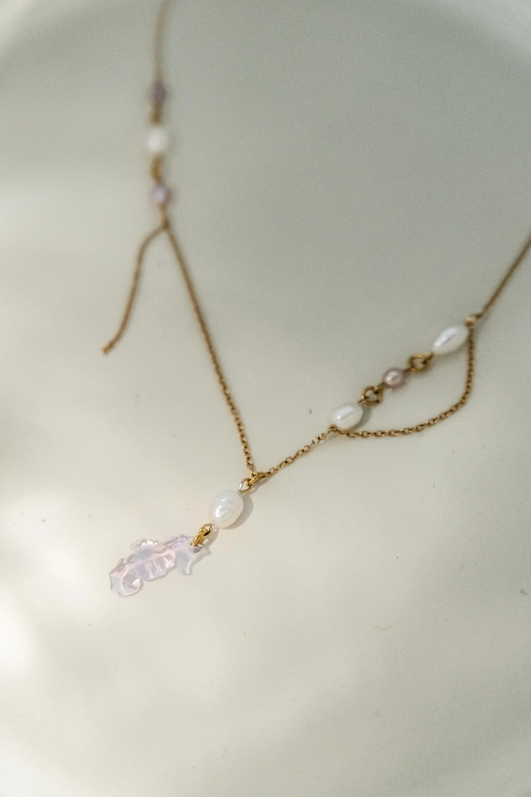Collier Seahorse en chaîne dorée avec perles d'eau douce blanches et mauves et charm hippocampe violet, collection Mermaid Odyssée Bijoux