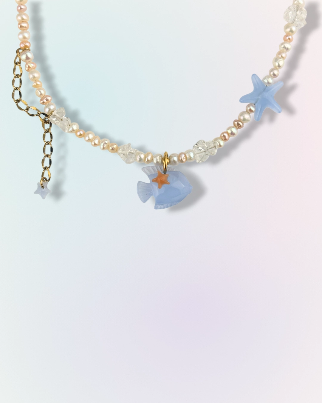 Collier Blue Tide en chaîne dorée avec perles d'eau douce, pierres naturelles et charms poisson et étoile de mer bleu, collection Mermaid Odyssée Bijoux