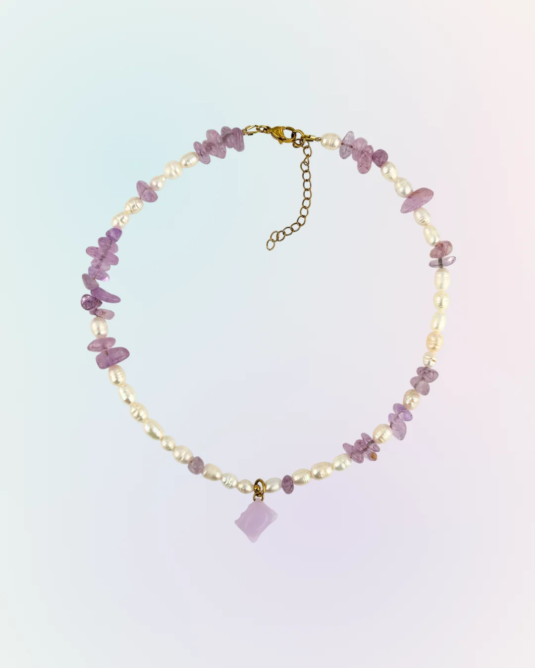 Collier Livre doré présenté à plat : perles d'eau douce, éclats d'améthyste et charm livre lilas