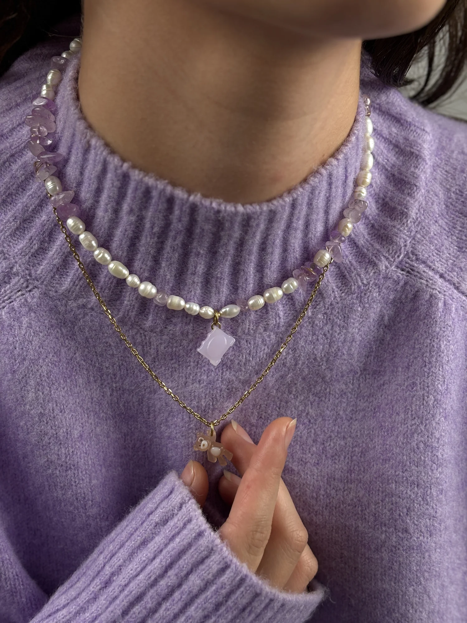 Collier Livre porté sur un pull lilas, associé à un second collier à chaîne dorée