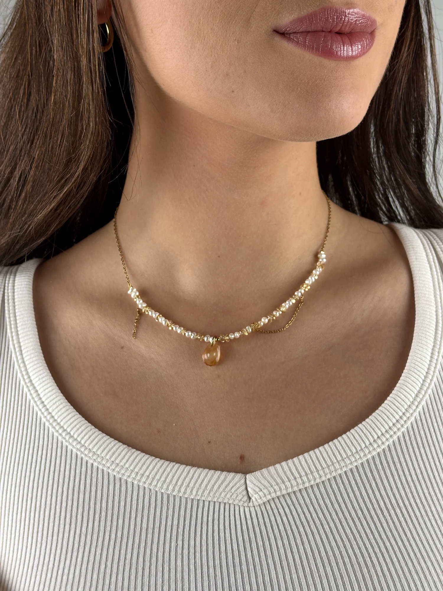 Collier Madeleine doré porté avec un débardeur blanc côtelé
