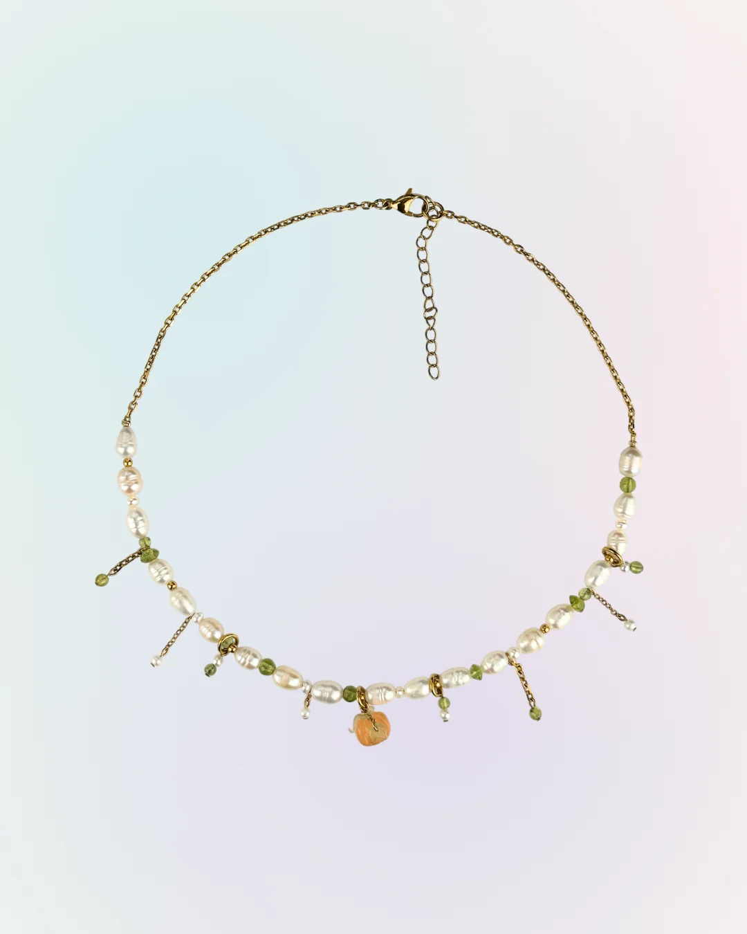 Collier Pumpkin doré présenté à plat : perles d'eau douce, pampilles de péridot et de petites perles, charm citrouille orange