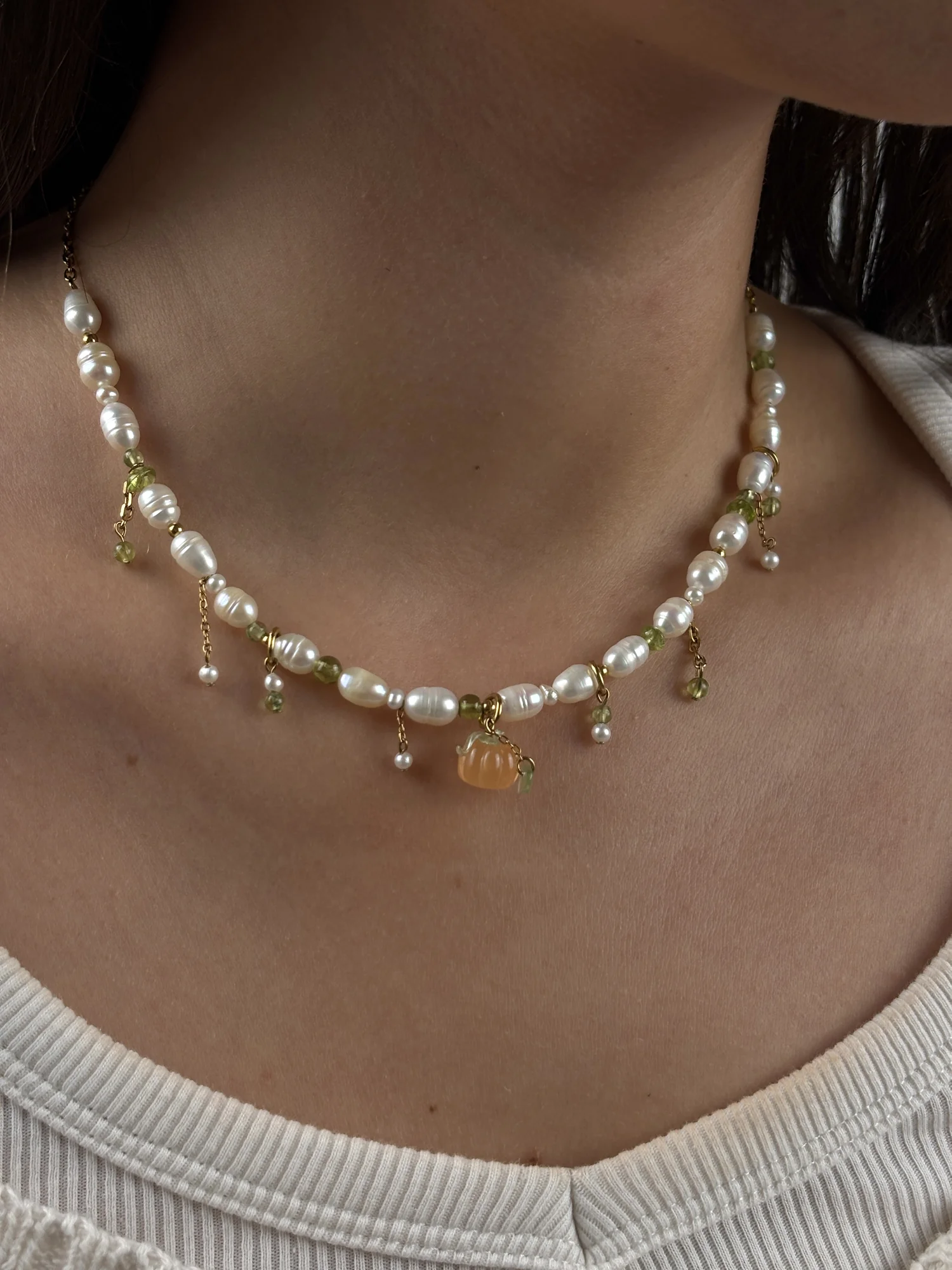 Collier Pumpkin doré porté : perles d'eau douce, pampilles de péridot et charm citrouille orange, collection Remember October Odyssée Bijoux