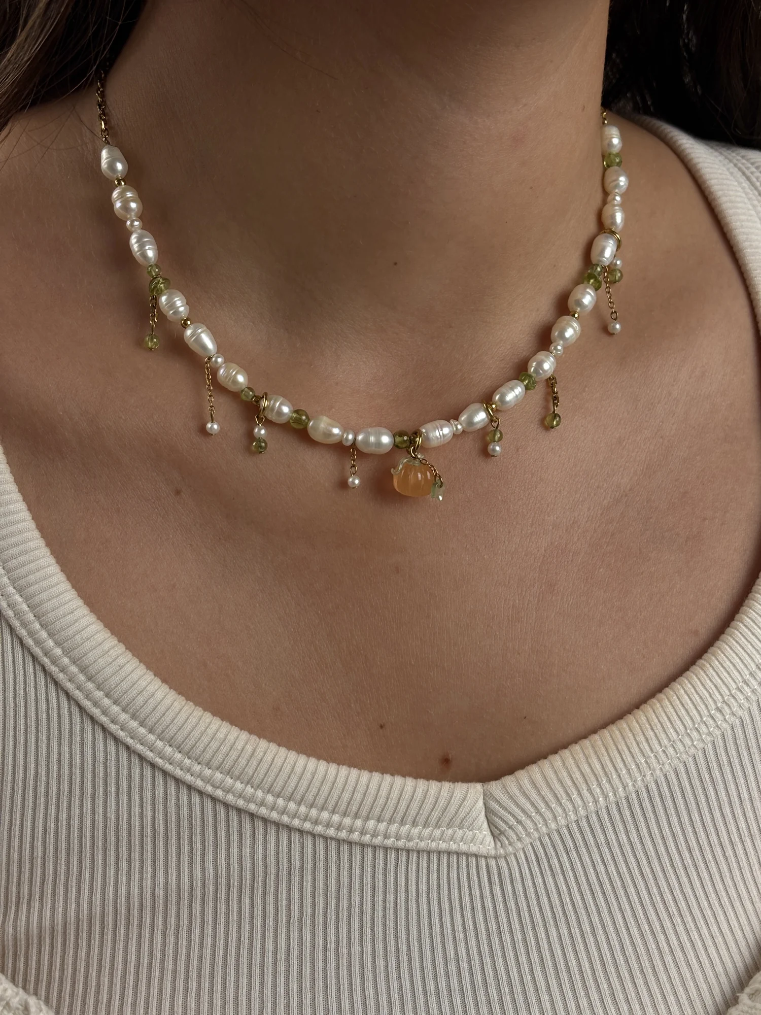 Collier Pumpkin doré porté de face sur un débardeur blanc