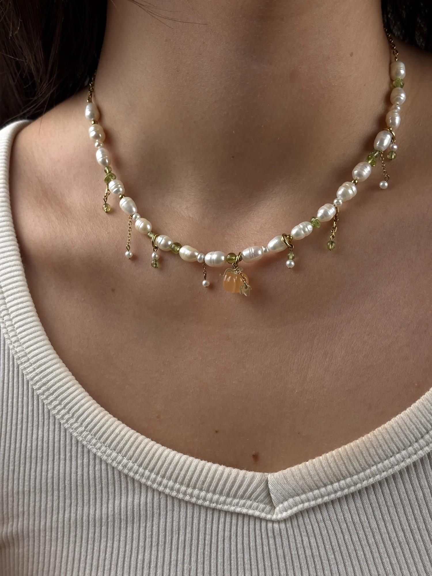 Collier Pumpkin doré porté de trois quarts, charm citrouille orange au centre