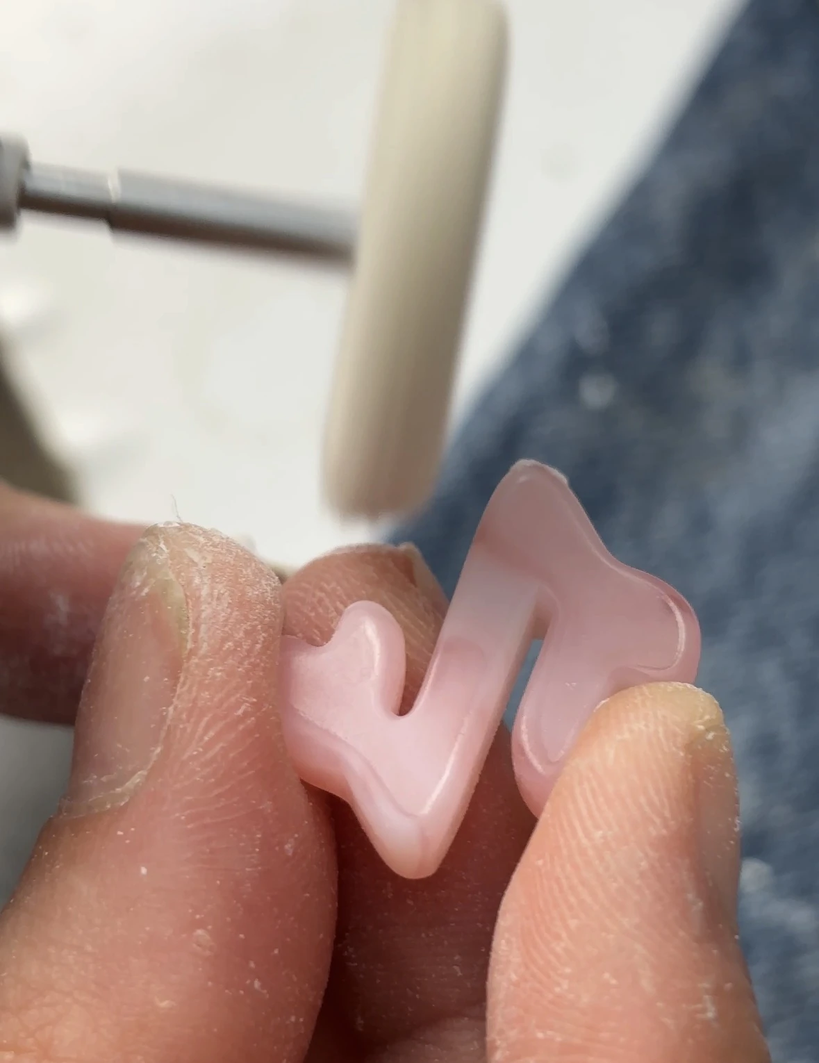 Polissage à la main d'un charm rose en forme de note de musique