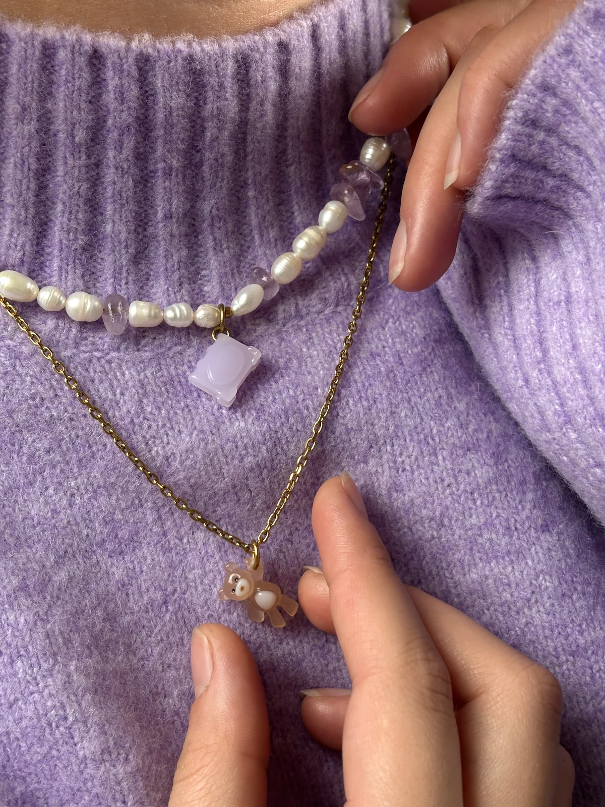 Collier Livre en perles d'eau douce et améthyste porté avec le collier Ourson Brun sur un pull lilas