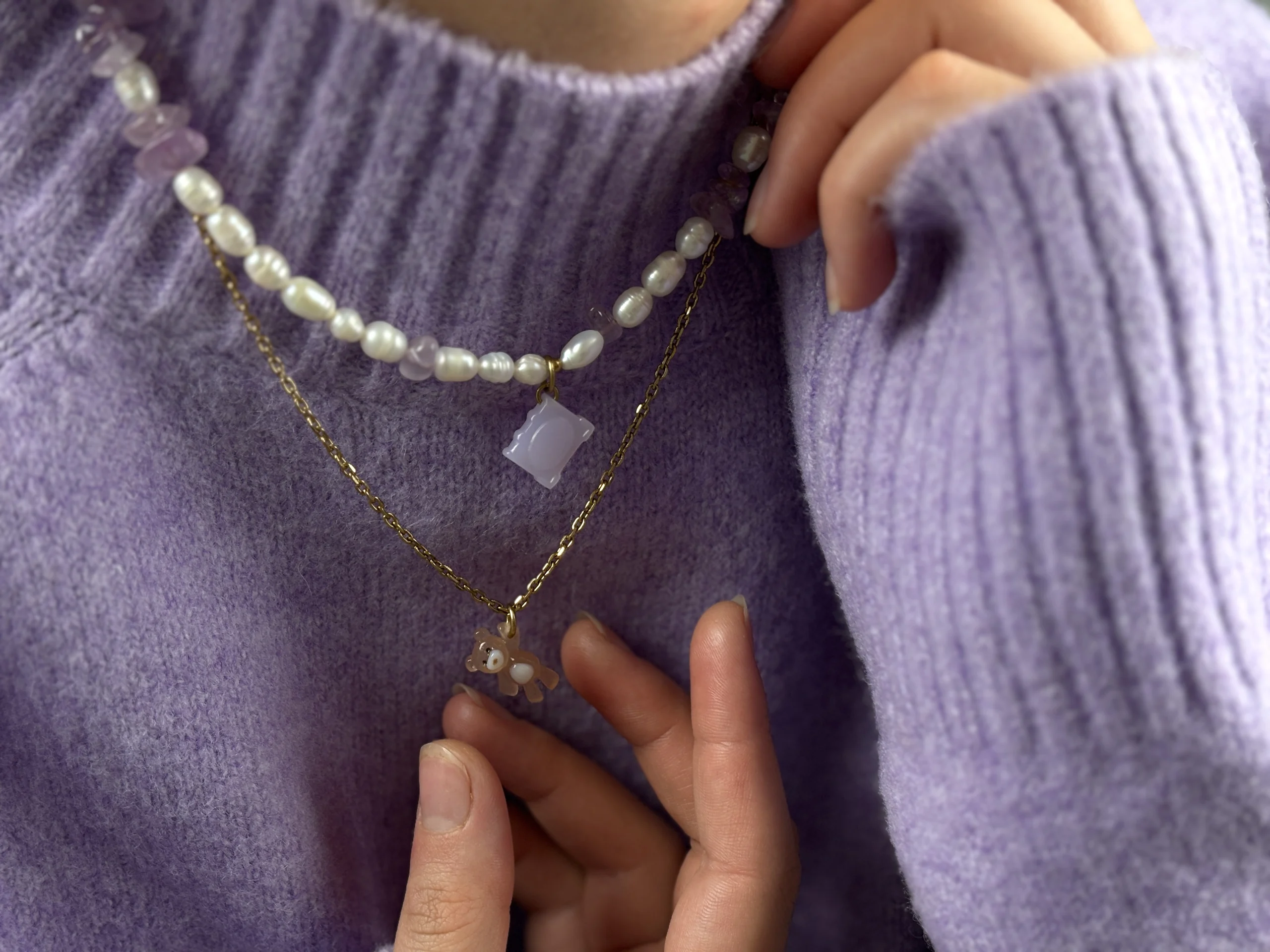 Collier Livre en perles d'eau douce et améthyste porté avec le collier Ourson Brun sur un pull lilas